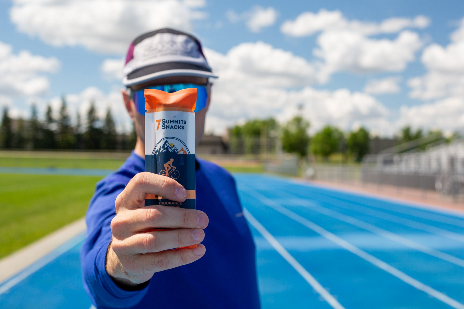 A runner holding up a 7 Summits Chocolate Energy Bar, made with real superfoods